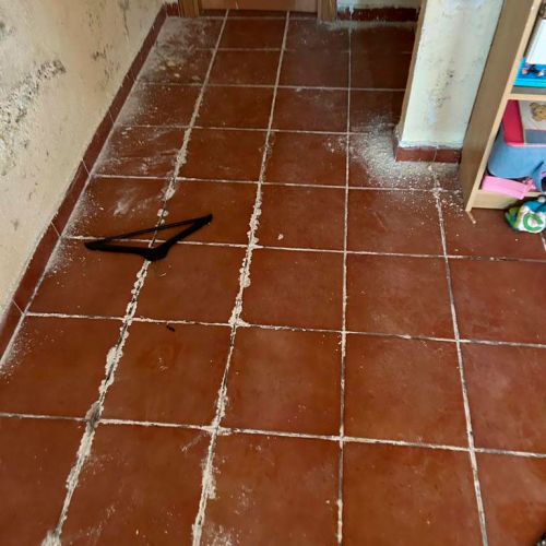 Baldosas rojizas sucias y estropeadas